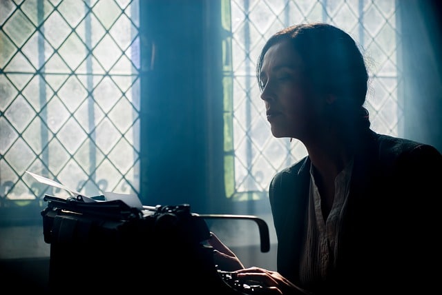 ragazza con macchina da scrivere davanti ad una finestra
